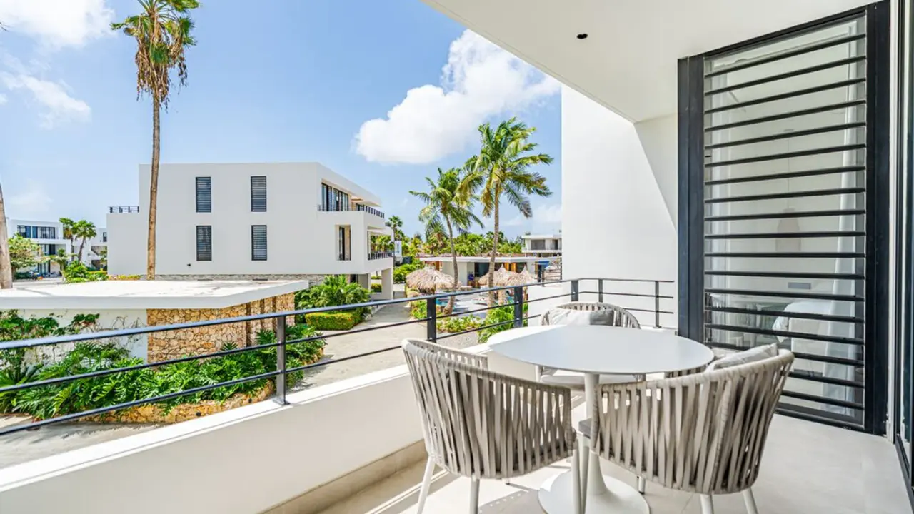 Balkon met tafel en stoelen boven de tuinen van het villa-eiland van Van der Valk Bonaire