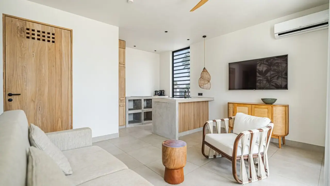Woonkamer met kitchenette en televisie in het Royal Residence 2-kamerappartement van Van der Valk Bonaire