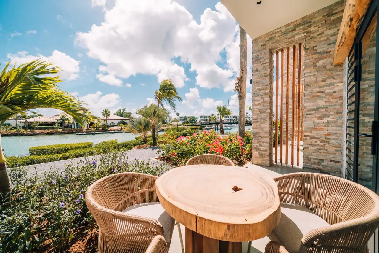 Terras van een Deluxe Room Laguna van Van der Valk Bonaire met houten tafel en uitzicht op de lagune