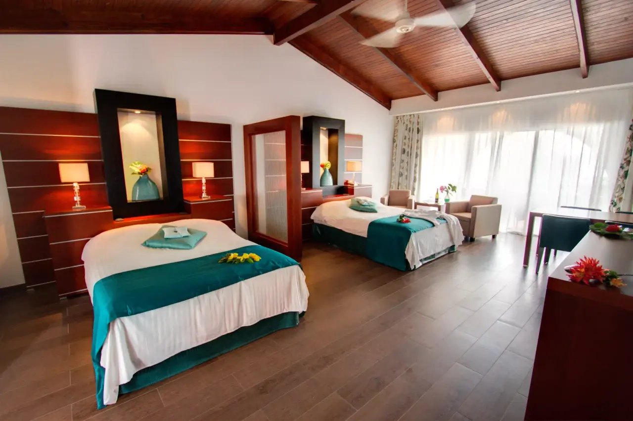 Grand Suite Laguna van Van der Valk Bonaire met twee bedden onder een schuin houten plafond