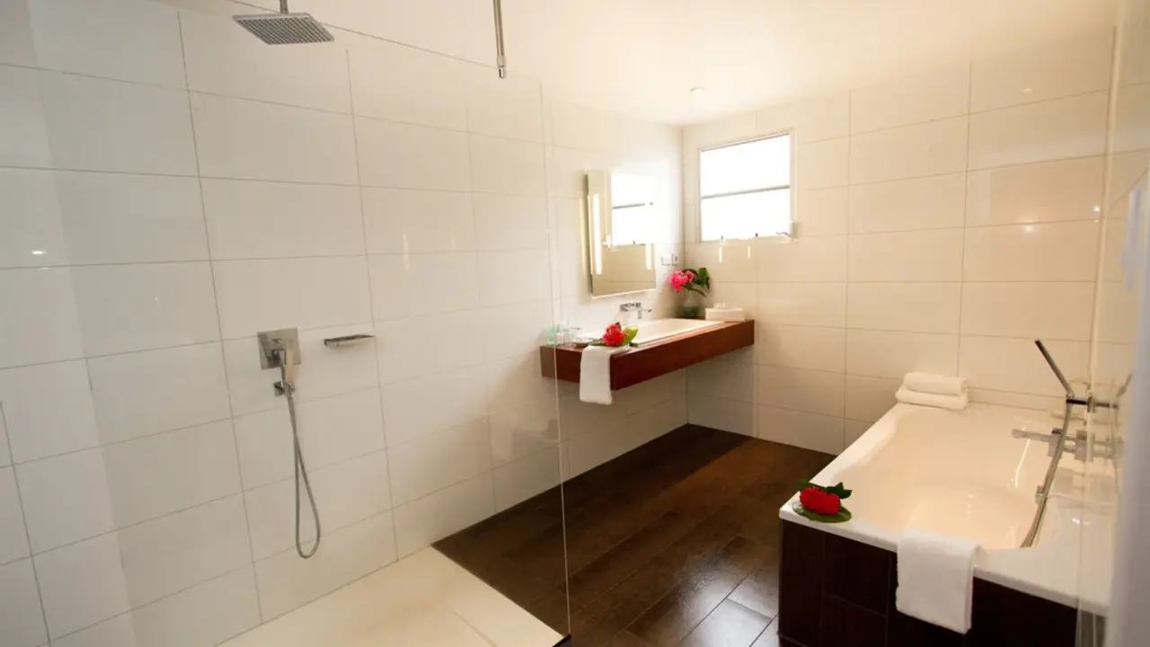 Open badkamer van een Grand Suite Laguna van Van der Valk Bonaire met inloopdouche en ligbad naast elkaar