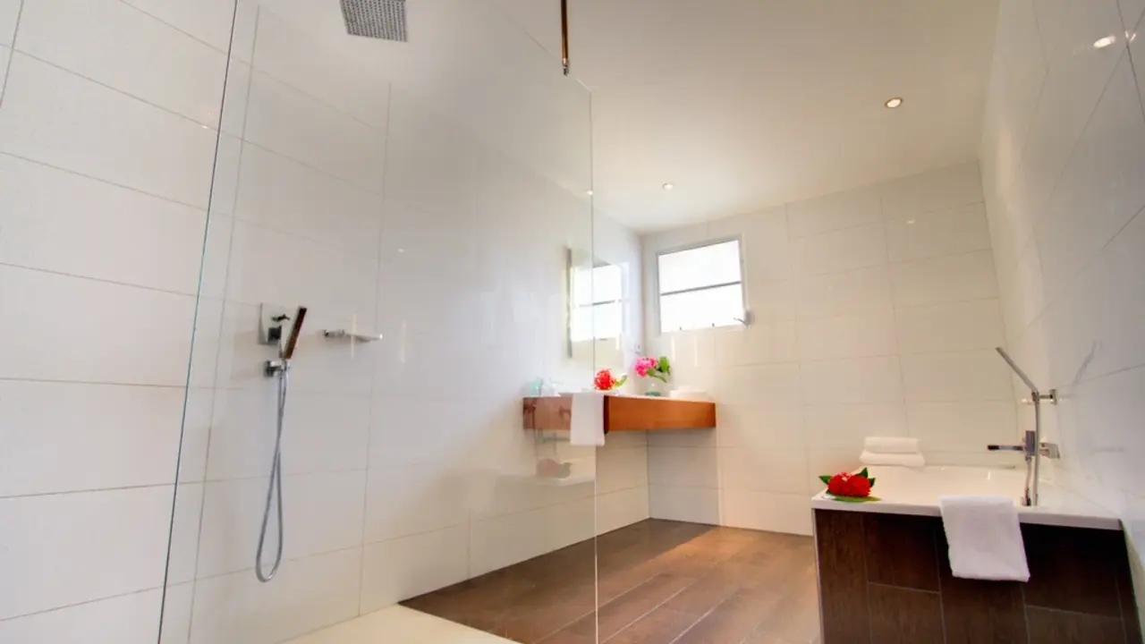 Open badkamer van een Grand Suite Ocean van Van der Valk Bonaire met glazen inloopdouche en ligbad