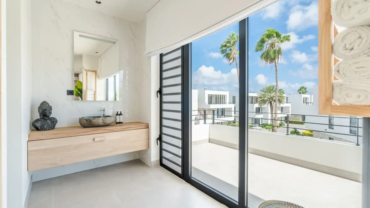 Wastafel met schuifpui naar het balkon in het Penthouse Laguna View van Van der Valk Bonaire