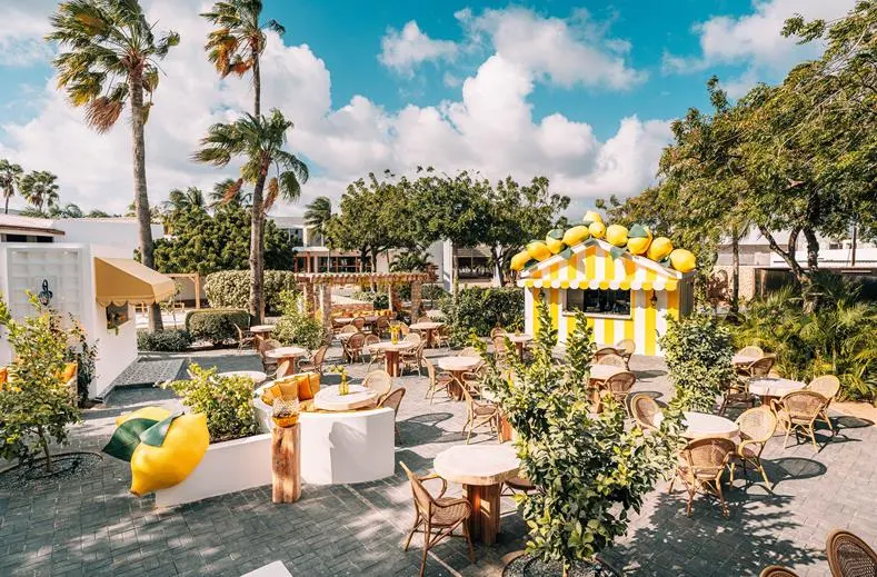 Het plein van Piazza Limone bij Van der Valk Bonaire met een geel-wit kraampje en terrastafels